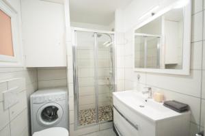 a white bathroom with a washing machine and a sink at Le Château 4 Pers AC WiFi Vecchia Nizza in Nice