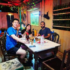 a group of people sitting at a table in a restaurant at Dream Vision Guest House in Diu