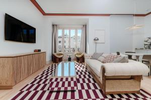 een woonkamer met een bank en een tv bij Apartamentos Soho Boutique Hoy No Me Puedo Levantar in Madrid