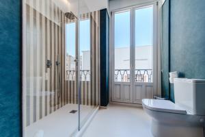 baño con aseo y puerta de ducha de cristal en Apartamentos Soho Boutique Hoy No Me Puedo Levantar, en Madrid