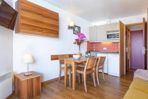 - une cuisine et une salle à manger avec une table et des chaises dans l'établissement Résidence & Spa Le Machu Pichu, à Val Thorens