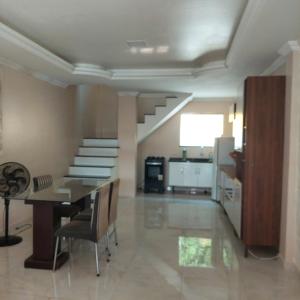 a living room with a staircase and a table and chairs at DUPLEX ALTO PADRÃO NO COND. OURO NEGRO - COROADO in Manaus