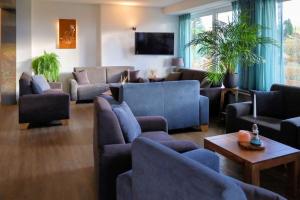 a living room with blue couches and a tv at Gruppenhaus Haus BerchStein in Winterberg