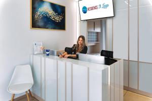 a woman sitting at a counter in an office at Residence iL Lago in Cluj-Napoca