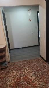 una stanza con una porta bianca e un tappeto di Квартира 3-х комнатная a Temirtaū