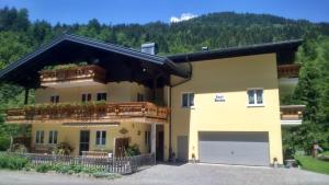 ein großes gelbes Haus mit Garage in der Unterkunft Haus Rosina in Mühlbach am Hochkönig