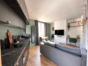 a kitchen and living room with a couch and a table at La place d'Henri, Rouen centre in Rouen