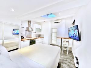 Una habitación blanca con una cama y una mesa dentro. en Èrsextius, VECA, Aix-en-Provence, en Aix-en-Provence