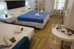 um quarto de hotel com duas camas e uma mesa em Polykratis Rooms em Skiathos