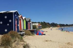 a beach with a group of colorful beach huts at Beachside Townhouse in Mornington