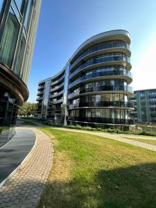 een groot gebouw met een grasveld ervoor bij Moon apartment in Druskininkai