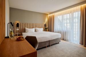 una habitación de hotel con una cama grande y una mesa en Hotel Verde, en Koszalin