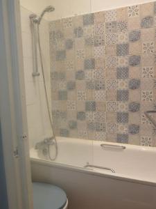 a bathroom with a shower and a toilet in a tub at Kent Gardens Apartment in Perivale