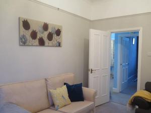 a living room with a couch and a painting on the wall at Kent Gardens Apartment in Perivale