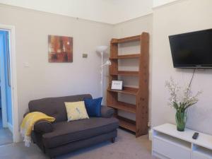 a living room with a couch and a flat screen tv at Kent Gardens Apartment in Perivale