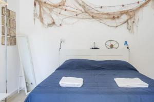 a bedroom with a blue bed with two towels on it at Al Khalisa Bright and cozy apt at Magione in Palermo