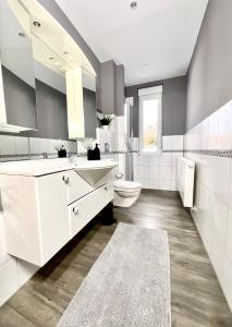 a bathroom with a white sink and a toilet at Haus Gitta - Wohlfühlen & Genießen in Luckenwalde