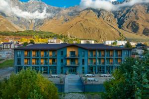 a building in front of a mountain at Intourist Kazbegi in Stepantsminda