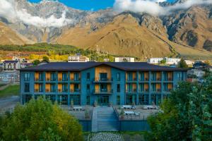 um edifício em frente a uma montanha em Intourist Kazbegi em Stepantsminda