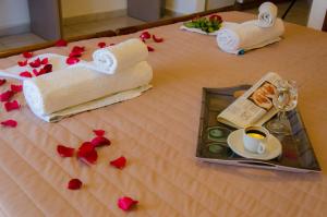 a table with towels and a cup of coffee and roses at Polykratis Rooms in Skiathos Town