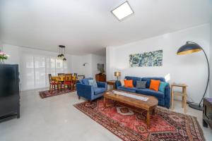 a living room with a blue couch and a table at Sun-Kissed Villa 