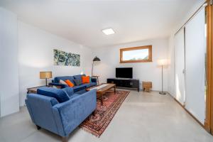 sala de estar con sofá azul y TV en Sun-Kissed Villa, 