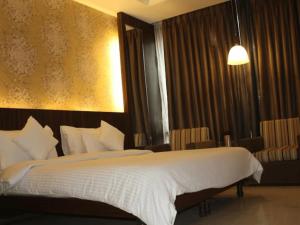 a bedroom with a large bed with white sheets at Hotel Panickers Residency - Ajmal Khan Market Karol Bagh in New Delhi