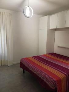 ein Schlafzimmer mit einem Bett mit einer bunten Decke in der Unterkunft Casa Cavour 153 in Cori