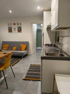 eine Küche und ein Wohnzimmer mit einem Sofa und einem Tisch in der Unterkunft Casa Cavour 153 in Cori