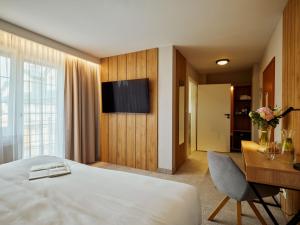 a hotel room with a bed and a desk and a television at Hotel Verde in Koszalin