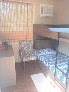 a bedroom with a bunk bed and a chair at Casa Container com piscina. Sem a tenda da frente in Bonito