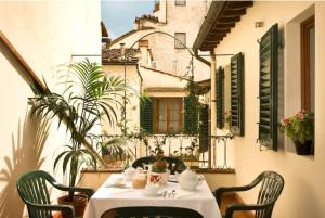 a table with a white table cloth and chairs on a balcony at Palazzo Antellesi in Florence