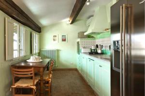 a kitchen with a table and a kitchen with green cabinets at Palazzo Antellesi in Florence