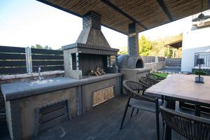 a outdoor kitchen with an outdoor oven on a deck at Villa Kriton Smart home in Máyiras
