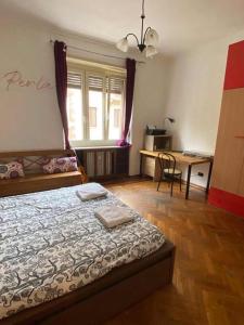 a bedroom with a bed and a table and a desk at La Perla di Vanchiglia (500 meters from the Mole) in Turin