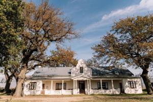 an old white house with trees in front of it at La Bri Guesthouse in Rawsonville
