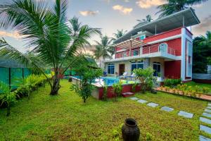 a house with a swimming pool and a yard at Spicy Mango Villa Elegano - Luxurious Villa Near Nagaon Beach, Alibag in Nagaon
