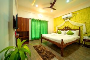 a bedroom with a bed with a green curtain at Spicy Mango Villa Elegano - Luxurious Villa Near Nagaon Beach, Alibag in Nagaon