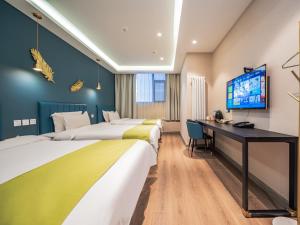 a hotel room with three beds and a desk at Wutong ins Designer Hotel in Xi'an