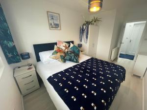 Schlafzimmer mit einem Bett mit einer schwarzen und weißen Bettdecke in der Unterkunft The Blue Crab in Bournemouth in Bournemouth