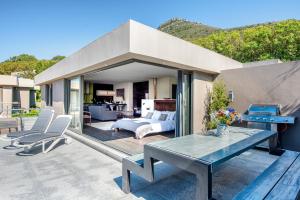 a patio with a bed and a table and chairs at Endless Views in Cape Town