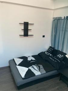 a bedroom with a bed with a black and white blanket at Arany Apartman in Cegléd