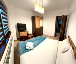 CRISTAL Home Boutique Apartment 1 - Confort, Spatios, Linistit, Zona de interes في كرايوفا: غرفة نوم بسرير كبير وتلفزيون