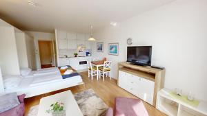 ペルツァーハケンにあるNeuKlosterhof App. 16のリビングルーム(ベッド1台付)、キッチンが備わります。