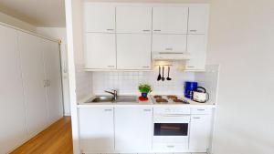 ペルツァーハケンにあるNeuKlosterhof App. 16の白いキッチン(白いキャビネット、シンク付)