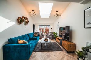 sala de estar con sofá azul y TV en Luxurious 3 Bed Home, Free Parking en Mánchester