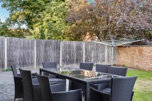 a table and chairs in a backyard with a fence at Rainfall shower I Parking x4 I Windsor I Legoland in Maidenhead