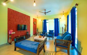 a living room with a couch and chairs and a tv at Spicy Mango Villa Elegano - Luxurious Villa Near Nagaon Beach, Alibag in Nagaon