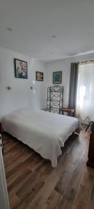 1 dormitorio con 1 cama grande y suelo de madera en gîte Aux Tourterelles, en Tournemire