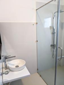 a white bathroom with a sink and a shower at The Aurelia in Gampola